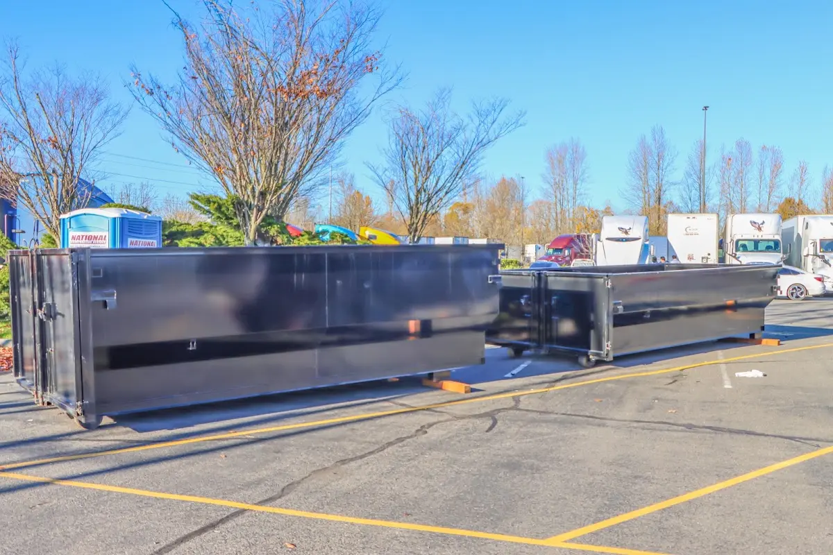 Professional dumpster rental service with roll-off container on residential driveway in Siloam Springs